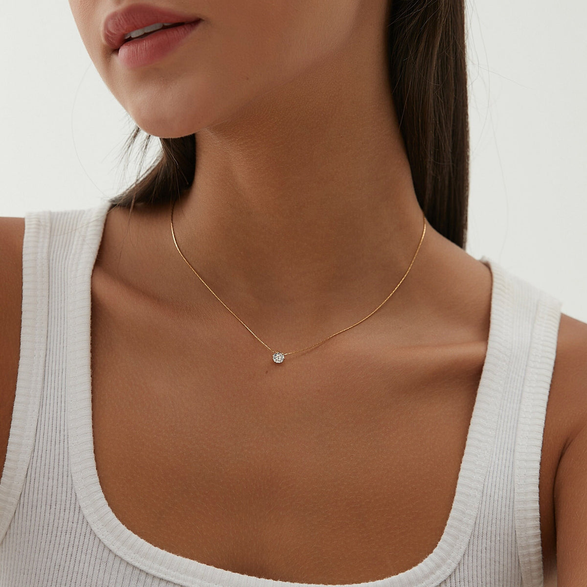 Collier pendentif zircon imitation diamant porté sur le décolleté, en acier inoxydable